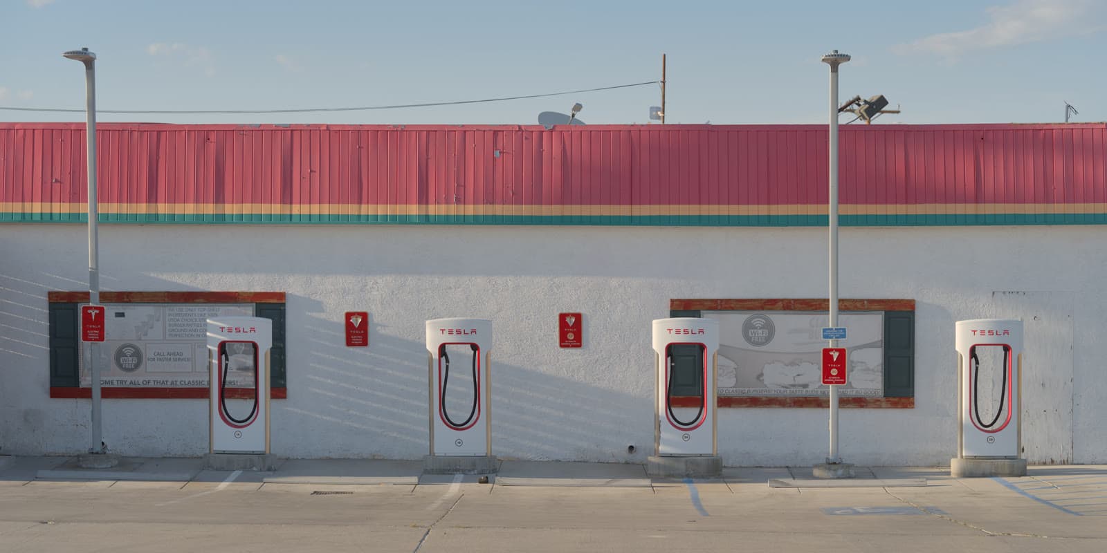 Four Tesla Supercharger stalls with vehicles charging in Inyokern, California